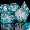 A close-up of a set of translucent blue liquid core dice, including a d6 and a triangular die, resting on a dark surface.