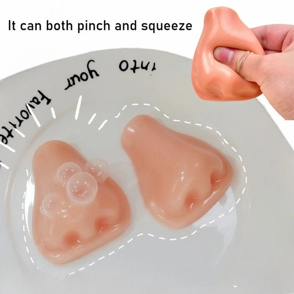 A pink silicone squeeze toy is shown being pinched and squeezed onto a white plate.
