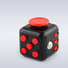 A black fidget cube with a red rotating top and magnetic buttons on the side.