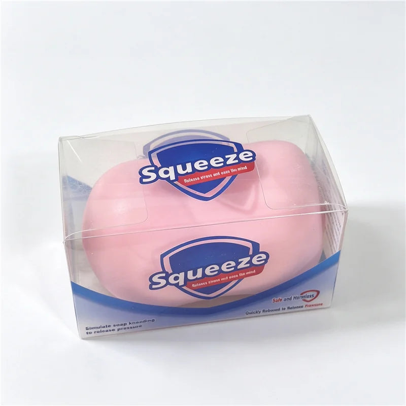 A clear plastic container holding a pink squishy fidget block for stress relief and sensory play.