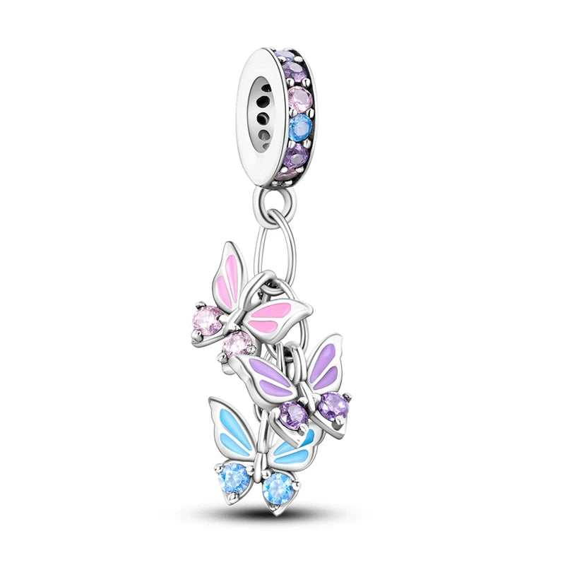 A silver heart charm bead featuring pink zircon stones and a butterfly pendant.