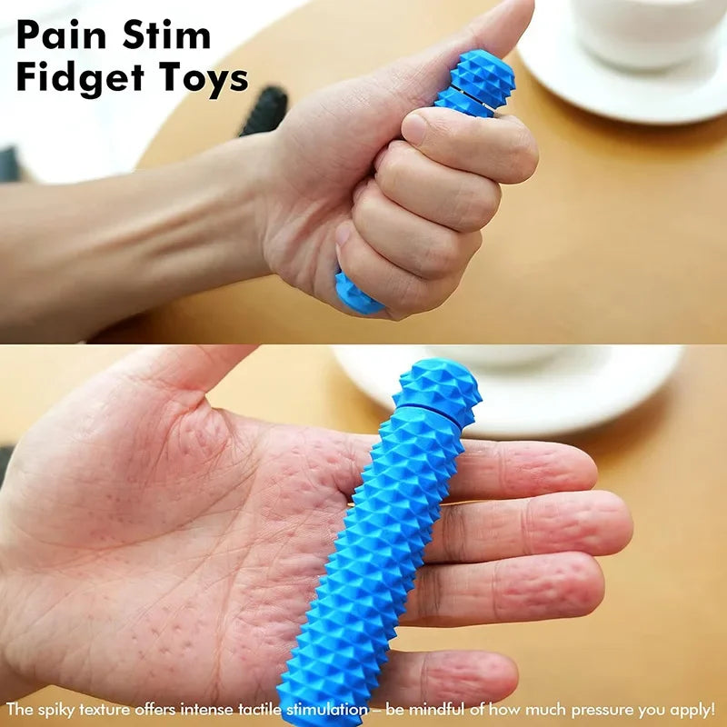 A hand is squeezing a blue spike roller fidget toy for tactile stimulation.