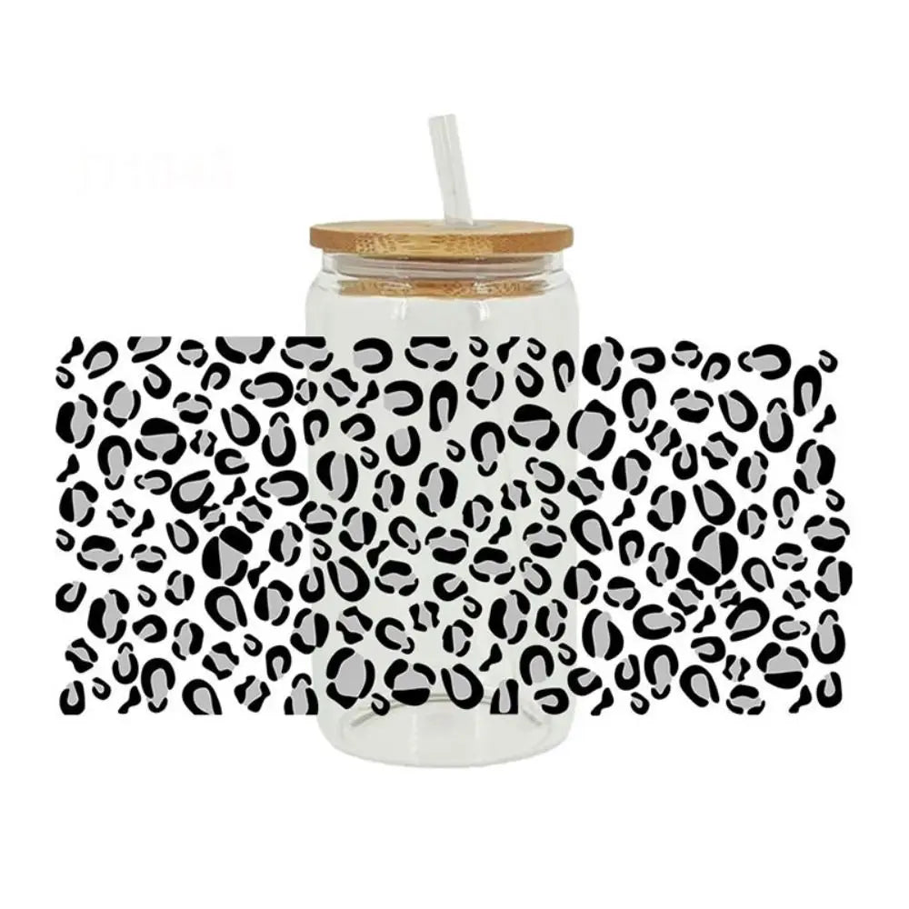 A glass jar with a lid and a straw, wrapped in leopard print transfer stickers.