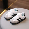 A pair of white and black casual sneakers resting on a light surface.