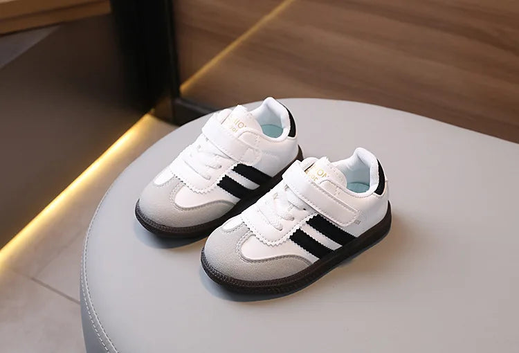 A pair of white and black casual sneakers resting on a light surface.