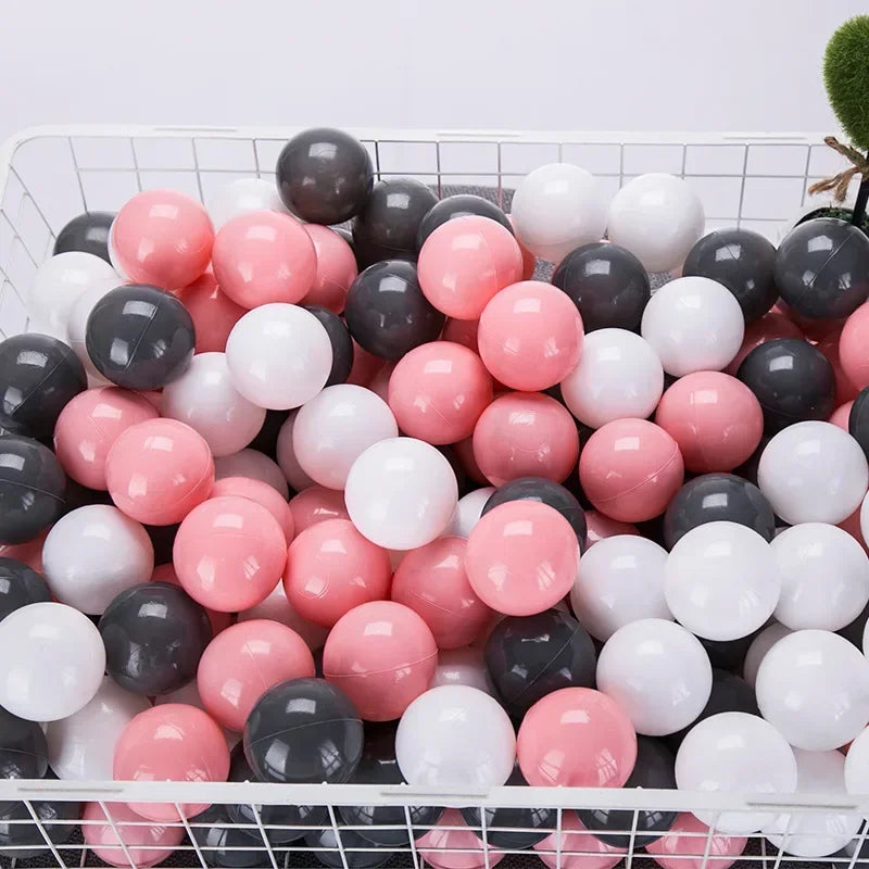 A white and pink ball pit filled with numerous colorful play balls for games