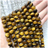 A stack of natural stone beads in various shades of brown and amber resting on a hand.