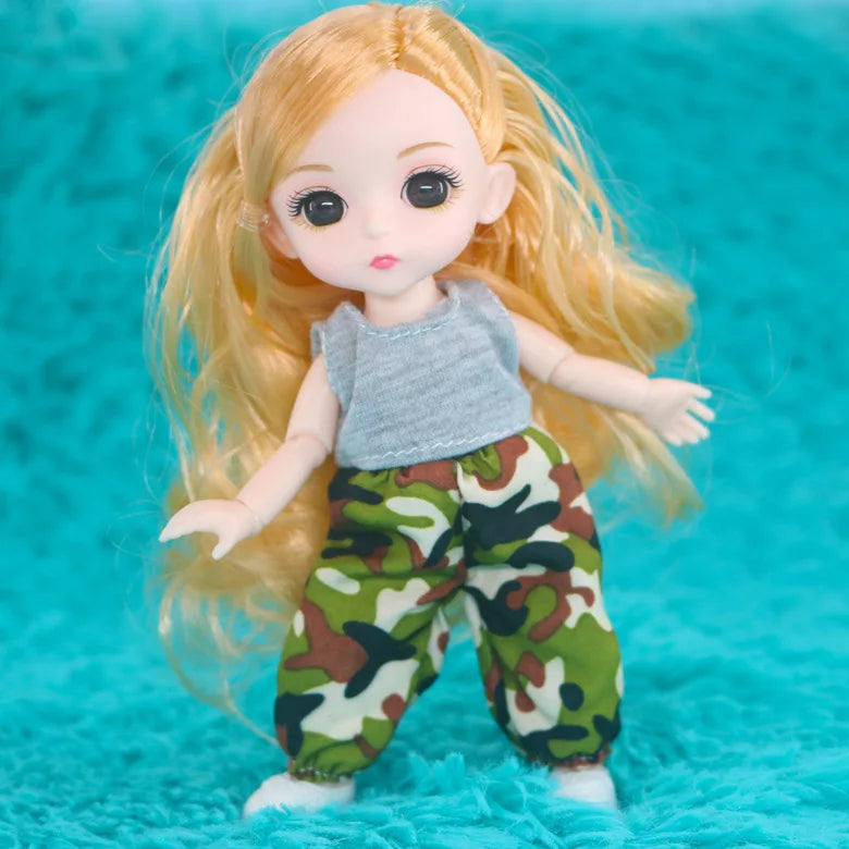 A blonde Articulated BJD princess doll with long hair wearing a gray top and camouflage pants.