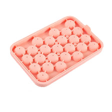 A pink silicone mold with multiple depressions shaped like grape clusters for soap and candle making.