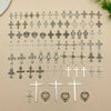 A collection of vintage silver cross charms and pendants for jewelry making displayed on a light background.