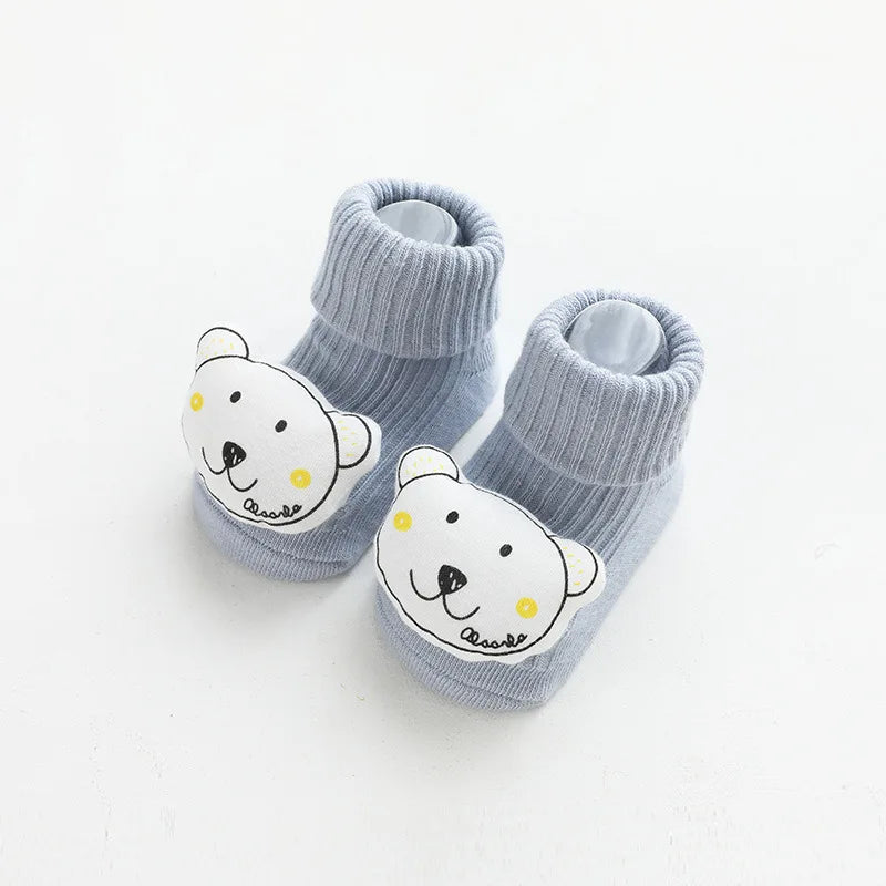 A pair of gray cotton socks featuring a white cartoon bear face with yellow accents.