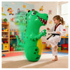 A large green inflatable dinosaur punching bag is positioned on a rug in a brightly lit room.