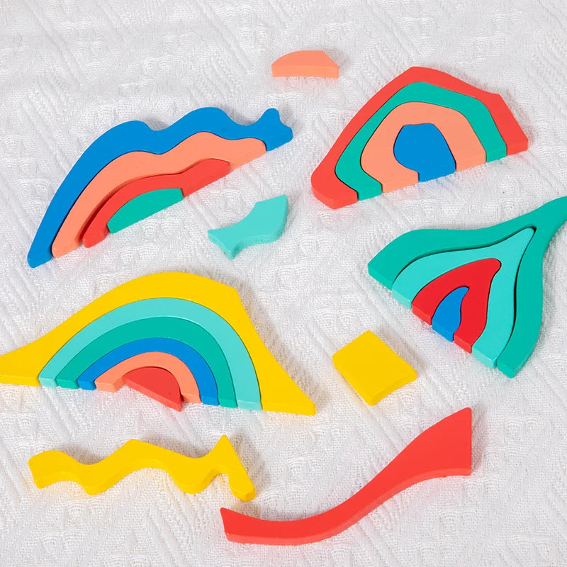 Colorful wooden rainbow blocks and puzzle pieces arranged on a white surface.