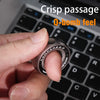 A hand holds a silver magnetic fidget ring on a black laptop keyboard.