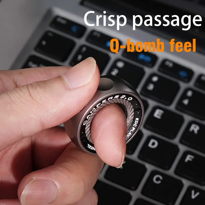 A hand holds a silver magnetic fidget ring on a black laptop keyboard.