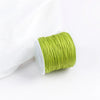 A roll of bright lime green macrame cord for jewelry making and crafts.