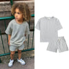 A gray kids summer tracksuit set featuring a short sleeve top and matching shorts.