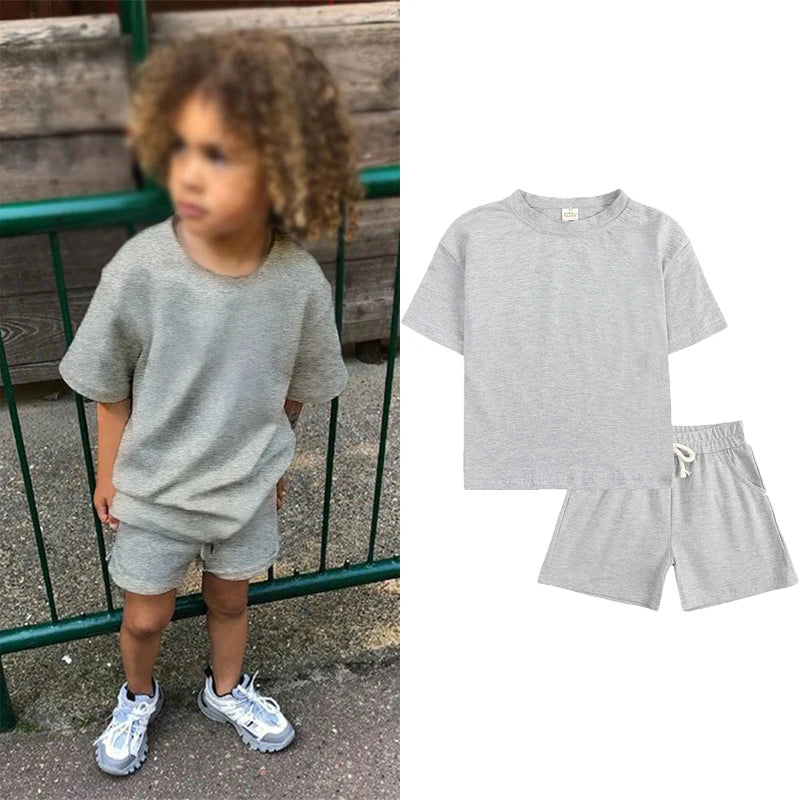 A gray kids summer tracksuit set featuring a short sleeve top and matching shorts.