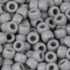 A close-up view of small, solid gray pony beads for jewelry making and craft projects.