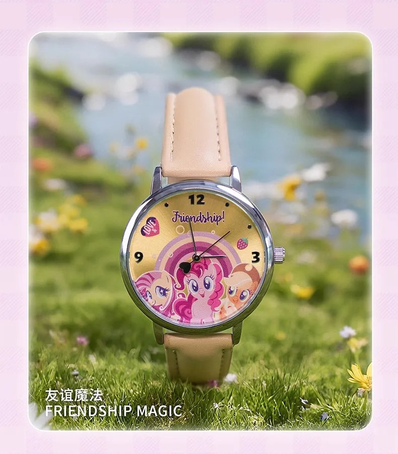 A pink and purple My Little Pony themed watch with a leather strap set in a natural outdoor background.