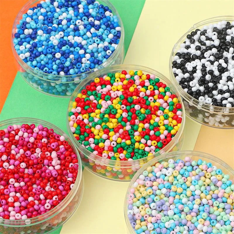 A collection of colorful pony beads in various shades including blue, pink, green, and black, displayed in clear containers.