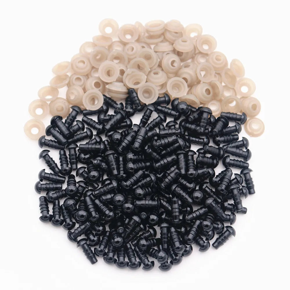 A pile of black plastic safety eyes with washers and a pile of natural colored eyes.
