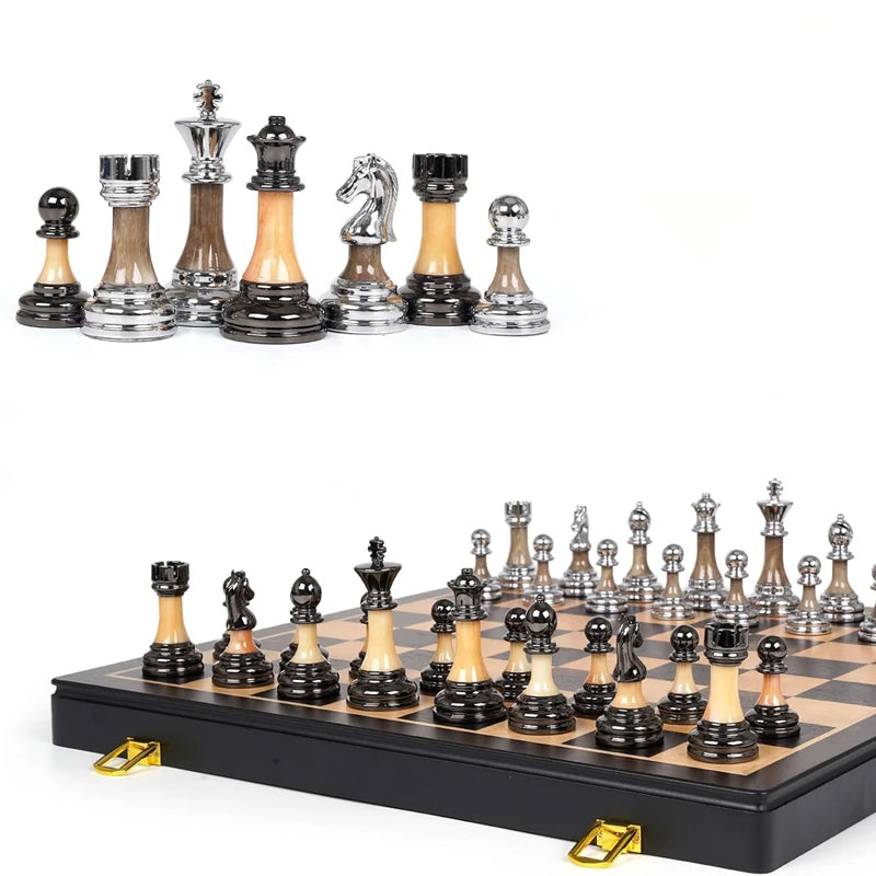 A collection of electroplated acrylic chess pieces displayed on a black board.