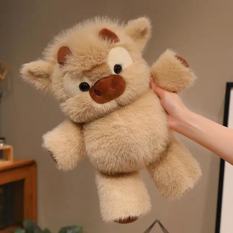 A light tan West Highland Calf plush toy with brown accents is being held by a hand.