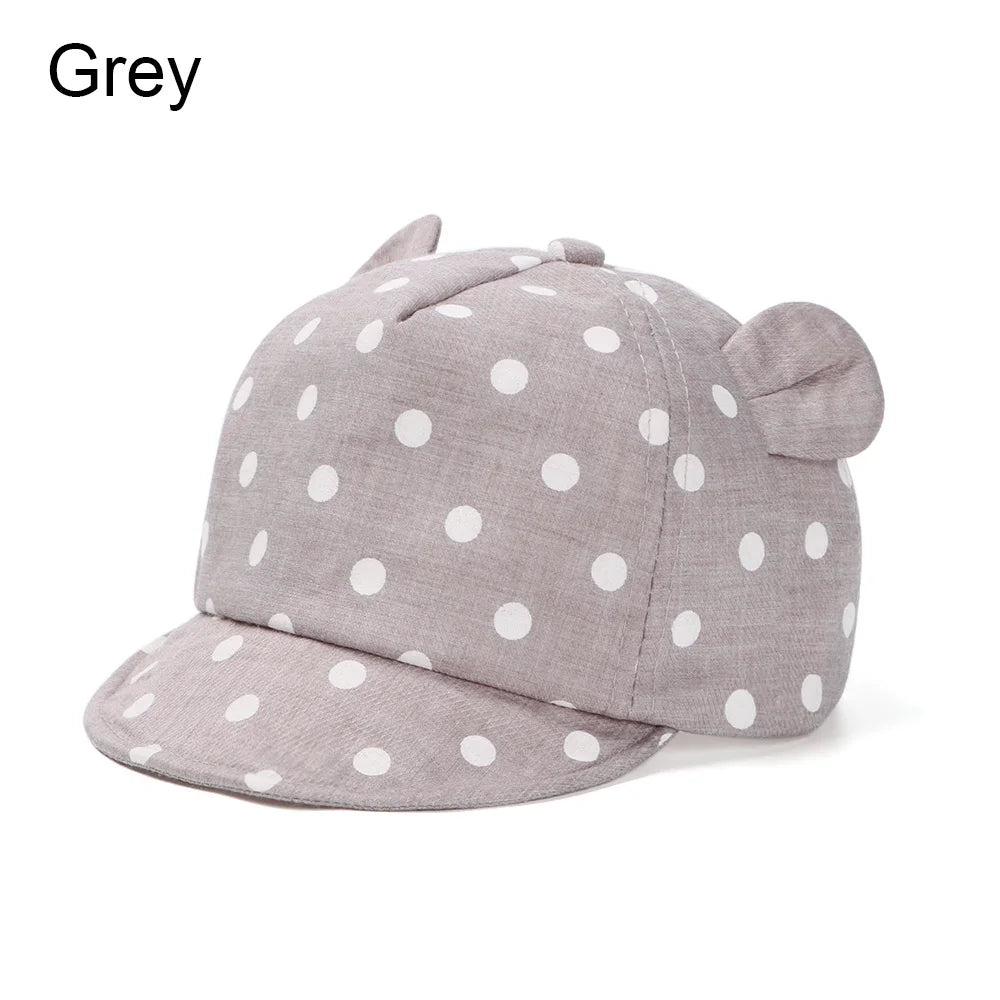 A light grey baby cotton baseball cap featuring a pattern of white polka dots and cute rabbit ears.