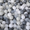 A close-up view of a large quantity of colorful plastic play balls in various shades of white, gray, and light blue.
