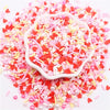 A pile of pink and red polymer clay sprinkles mix used for slime decor and DIY craft accents.