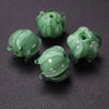 Several small, round, translucent green glass charms shaped like lily of the valley buds for jewelry making