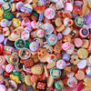 A colorful assortment of miniature dollhouse snack food items including candies, jellies, and baked goods.