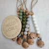 A string of natural wooden and silicone beads used as a pacifier clip or teether.