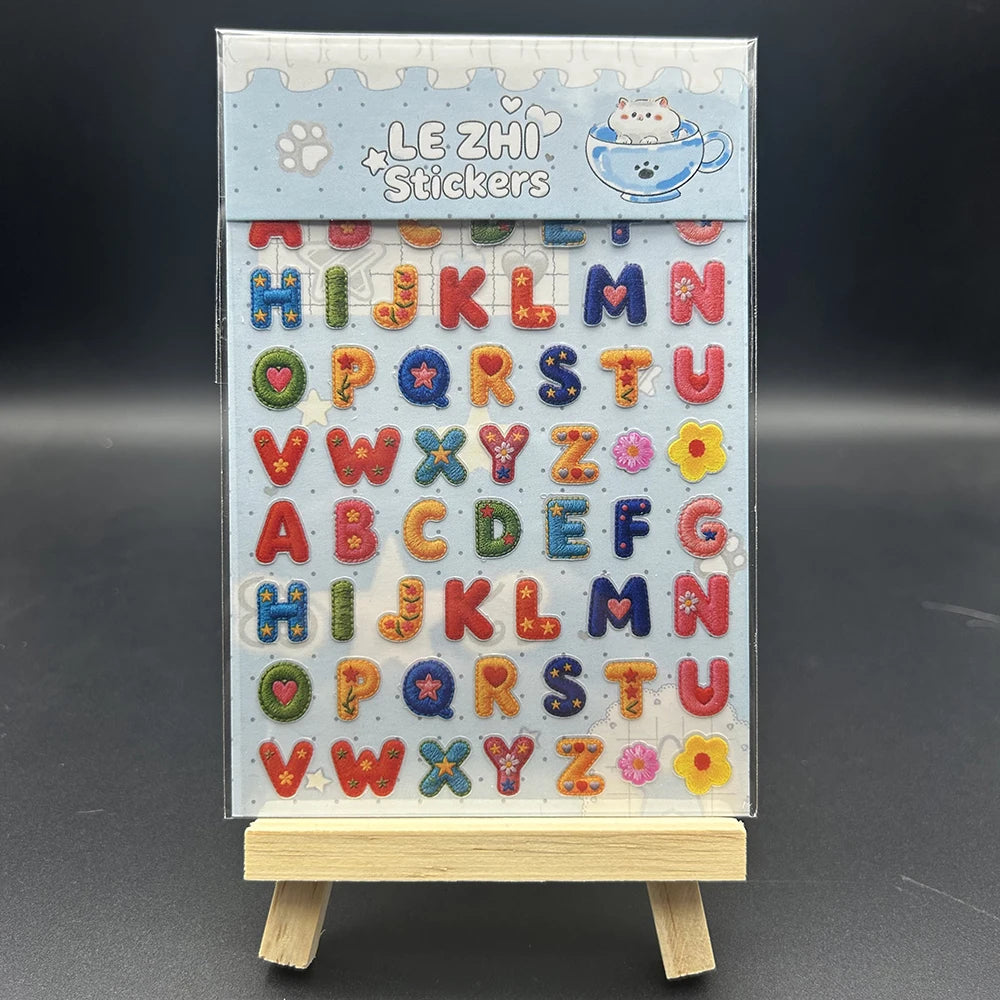 A sheet of decorative alphabet stickers featuring lowercase and uppercase letters, stars, and a cat design.