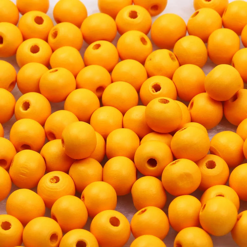 A pile of bright orange natural wooden beads for jewelry making and DIY crafts.