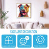 A framed painting of a dog's head with vibrant colors, displayed above a sofa.