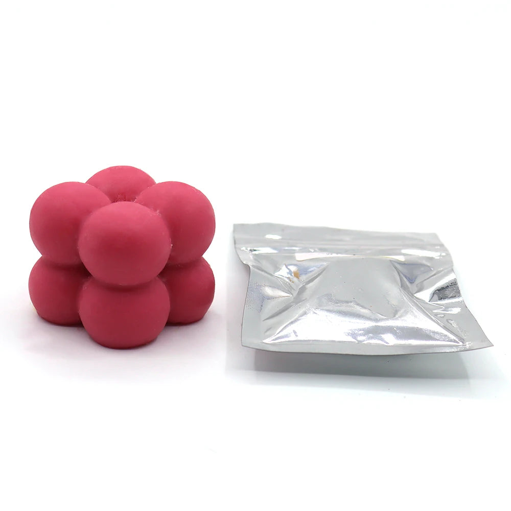 A pile of pink candle dye chips for soy wax, beeswax, and paraffin wax.