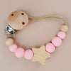 A wooden pacifier clip featuring silicone beads and a star shape, attached to a light-colored cord.