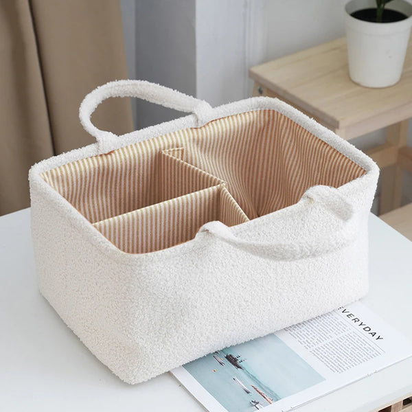 Eine cremefarbene, flauschige Organizer-Tasche mit Deckel auf einer weißen Oberfläche.