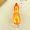 An orange, glittery duck squeeze toy with a red beak and white feet resting on a light background.