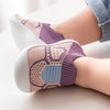 Close-up of a pair of purple and beige breathable anti-slip baby first walker shoes on a white surface.