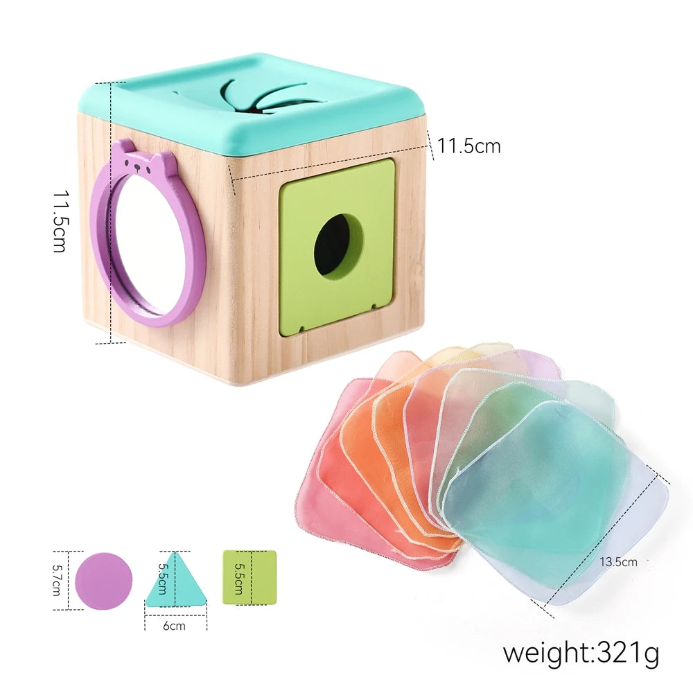 A light wood tissue box with a purple ring and a green window, next to colored silicone tissue pads.