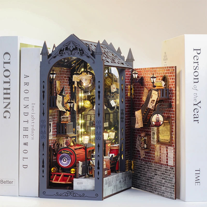 A DIY wooden book nook kit featuring a detailed miniature scene with LED lights and brick background.