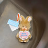A fluffy brown rabbit plush toy with a heart-shaped tag that reads We are sweet sugar friends