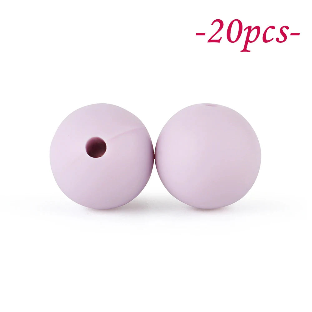 Two round, pink silicone beads are shown against a white background.
