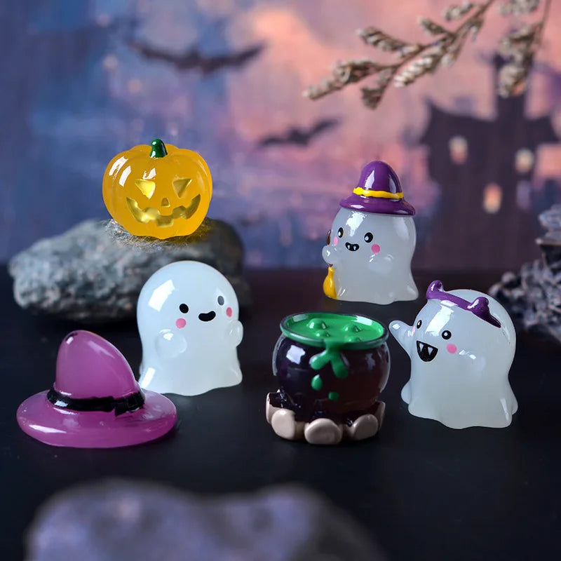 Colección de adornos de calabaza fantasma brillante, incluyendo una calabaza tallada y varios fantasmas blancos y morados