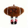 A brown plush sports ball keychain with stitched lines and gray and red striped feet.