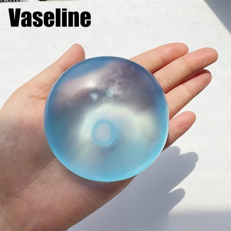 A hand holds a translucent blue silicone fidget ball for stress relief and focus.