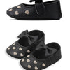 Black baby girl shoes with a bow knot design and small gold heart embellishments